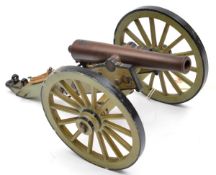 A model cannon, brass barrel, grey and black painted carriage, 10½” overall, nicely detailed, on a