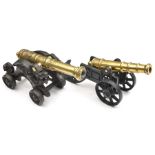 A decorative modern model cannon, with 11” cast brass barrel, on cast iron 2 wheeled carriage; and