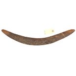 A darkwood boomerang, the rounded side with shallow incised linear panels, the tips and flat