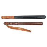 A blackened wood truncheon, ribbed light wood grip, 17½”, and another brown wood truncheon, shaped