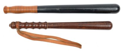 A blackened wood truncheon, ribbed light wood grip, 17½”, and another brown wood truncheon, shaped