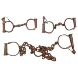 A pair of leg irons and chains, stamped “88”; 2 pairs handcuffs, stamped “Hiatt Best” and “Wrought