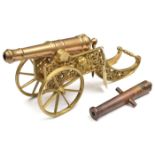 A decorative modern model cannon, the 12” bronze barrel of good form, on its two wheeled brass