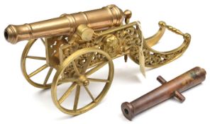 A decorative modern model cannon, the 12” bronze barrel of good form, on its two wheeled brass