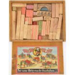 An early Third Reich box of child’s wooden building blocks, the sliding wooden lid with coloured