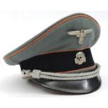A Third Reich SS officer’s peaked cap, with faded orange piping for Feldgendarmerie and silver