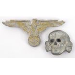 A Third Reich Waffen SS white metal cap eagle and skull pair, both marked “RZM” and “SS 373/43”. GC