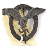 A Third Reich Pilot’s badge, of dark grey metal, the eagle with deeply impressed circle (looks