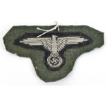 A Third Reich Waffen SS officer’s or NCO’s BeVo woven silver wire arm eagle, removed from a tunic