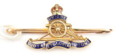 A tie pin brooch of The R Artillery, blue and red enamelled, stamped “15CT”. GC Plate 3
