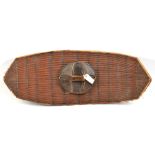 A well made Polynesian rattan shield, in fibre bound panels, panelled darkwood grip, 35” x 14” (