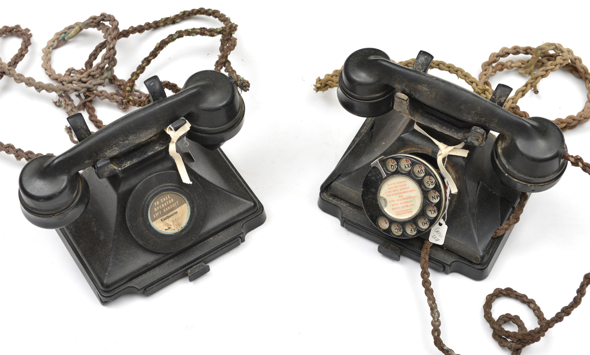 A black bakelite telephone c 1940, with Eastbourne number, GC; another similar badly damaged; also a