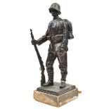 A bronzed spelter figure of a standing WWI German infantryman, wearing uniform with steel helmet,