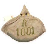 A WWI German linen pickelhaube cover, the front with green stencilled “R” over “1001”, the inside
