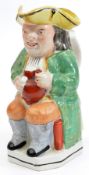 A 19th century Staffordshire Toby jug of traditional form, seated holding a jug, 9” high. GC