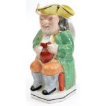 A 19th century Staffordshire Toby jug of traditional form, seated holding a jug, 9” high. GC