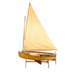 A model of a Victorian/Edwardian style sailing boat. A single masted wooden clinker built teak model