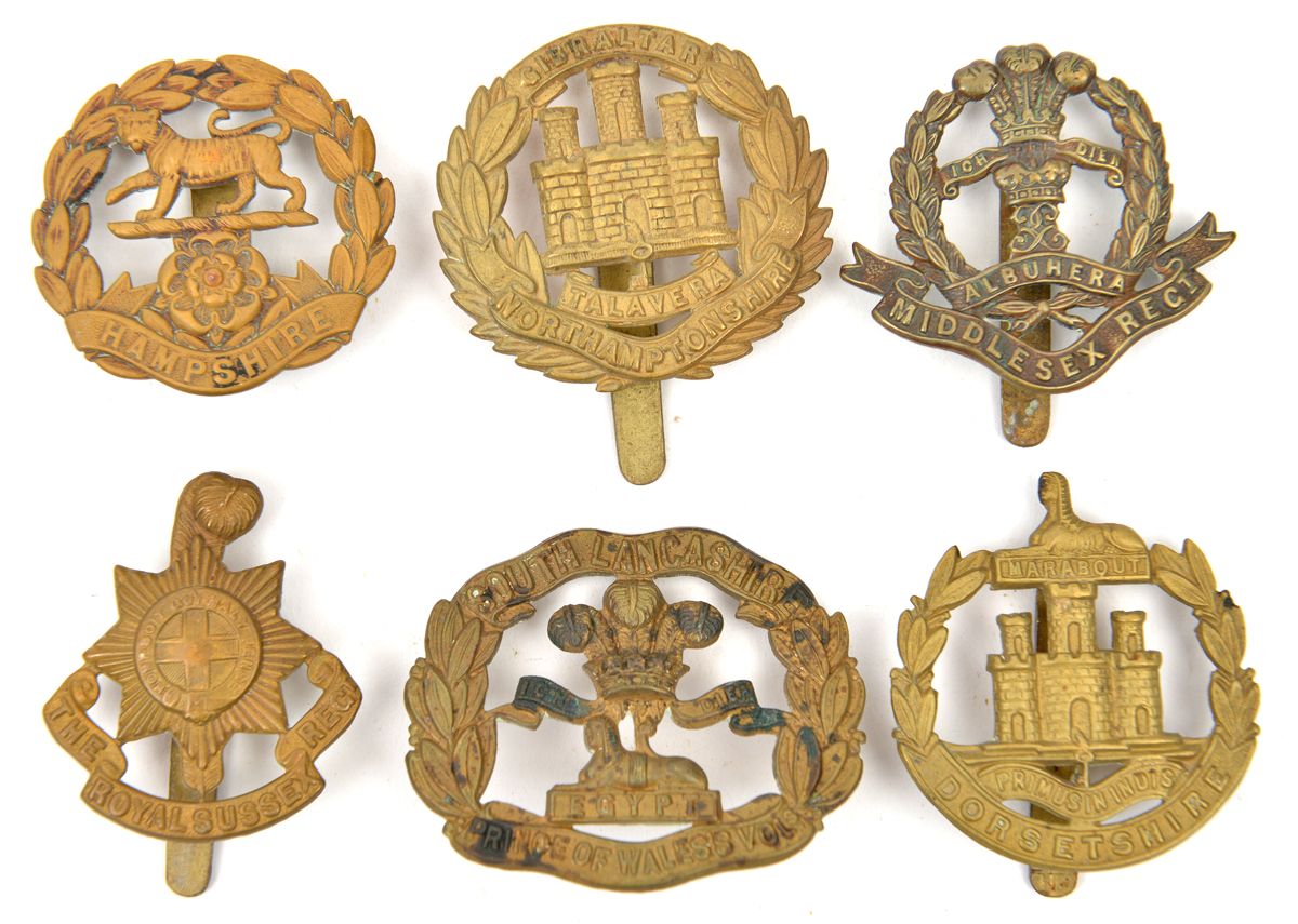 6 WWI all brass cap badges: R Sussex, Hampshire, Dorsetshire, S Lancs, Northants and Middlesex. GC