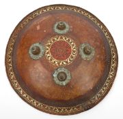 A 19th century Indian shield dhal, 4 brass bosses, decorated rim and centre circle, velvet grips and