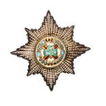 An ERII officer’s gilt and silver plated cap badge of the Irish Guards, enamelled centre.Near VGC