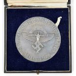 A Third Reich NSFK skiing award plaque, 3¼” diameter, with oxidised silver finish, embossed with