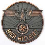 A Third Reich circular bronzed cast iron wall plaque, 5½” diameter, embossed with NSKK style eagle