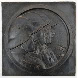 A blackened cast iron rectangular plaque, 10” x 10”, embossed with the heads of three German