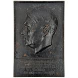 A black painted rectangular cast iron wall plaque, 8½” x 12½”, embossed with head of Hitler and