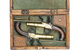 A pair of 28 bore brass cannon barrelled and brass framed silver mounted flintlock boxlock pistols