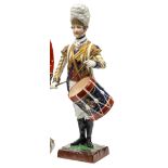 A painted porcelain figure “Drummer 3rd Guards”, in Georgian full dress with white mitre style fur