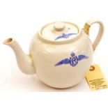A white glazed pottery teapot, the body and lid with blue transfer printed badge in the form of