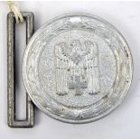 A Third Reich Red Cross leader’s circular aluminium belt buckle, the reverse stamped “Ges. Gesch”