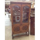 A 1920S OAK BOOKCASE WITH LEADED GLASS AND PANELLED DOORS