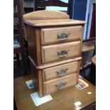 A NARROW CHEST OF FOUR DRAWERS