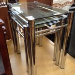 A GLASS TOP METAL NEST OF TABLES