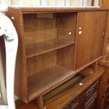 A RETRO TEAK BOOKCASE WITH SLIDING DOORS LABELLED 'GIBBS' L122CM D28CM H76CM