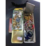 A TIN OF COSTUME JEWELLERY