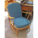 An Ercol blonde armchair with blue checked upholstered cushions.