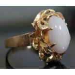 A yellow metal ring set with a white cabochon, marked '14K', gross wt. 7.5g, size O.