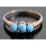 A yellow metal ring set with three turquoise cabochons, marks indistinct, gross wt. 1.5g, size M.