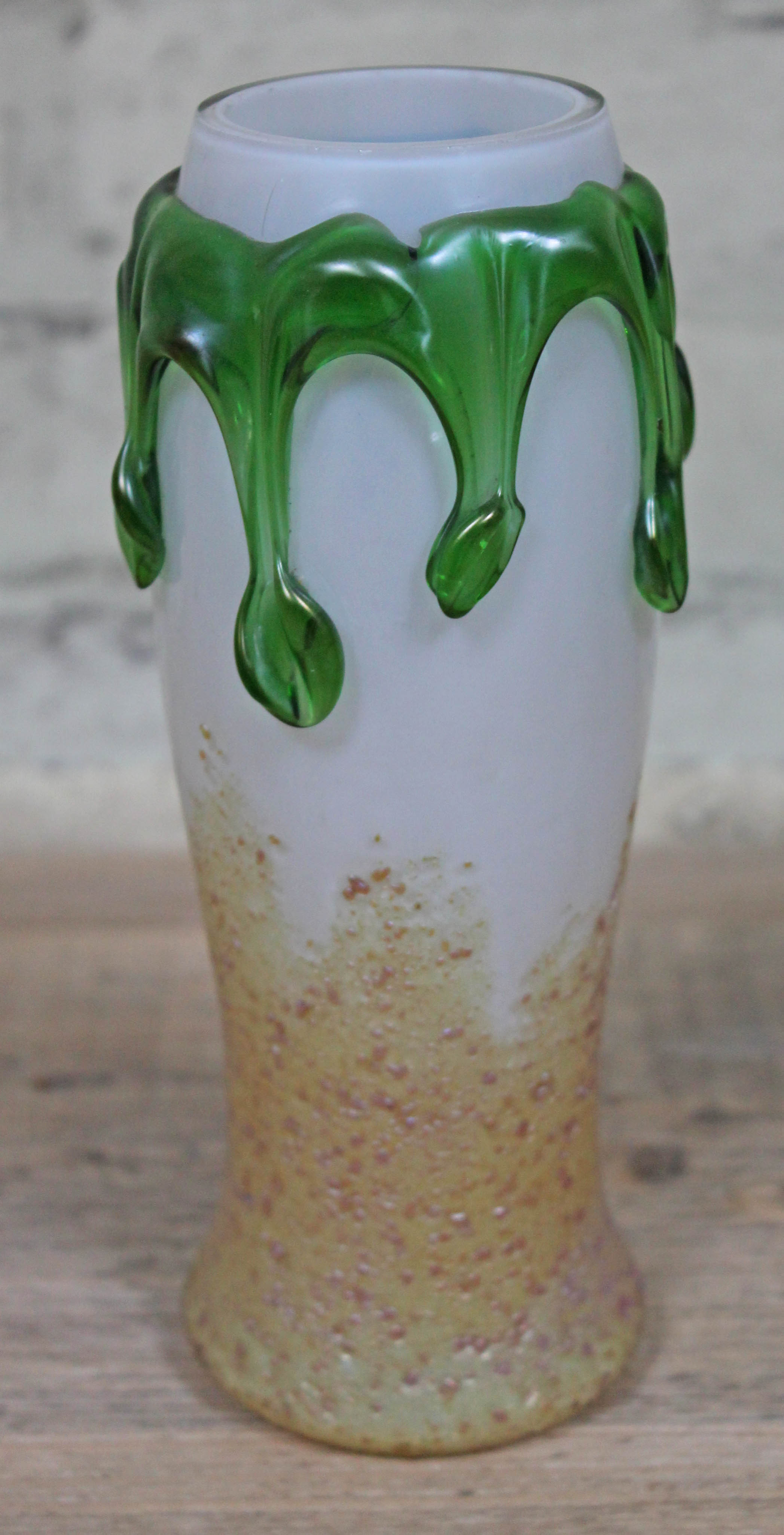 A Loetz style iridescent glass vase with applied green drips, height 21cm. Condition - minor nibbles