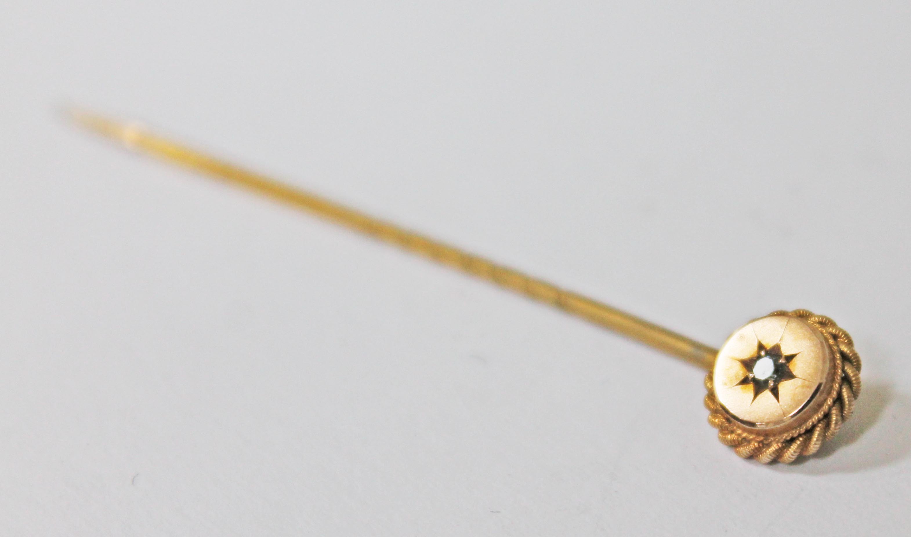 A yellow metal diamond stick pin marked '9ct', length 55mm, gross wt. 1g.