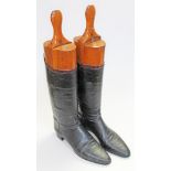 A pair of leather riding boots with wooden trees.