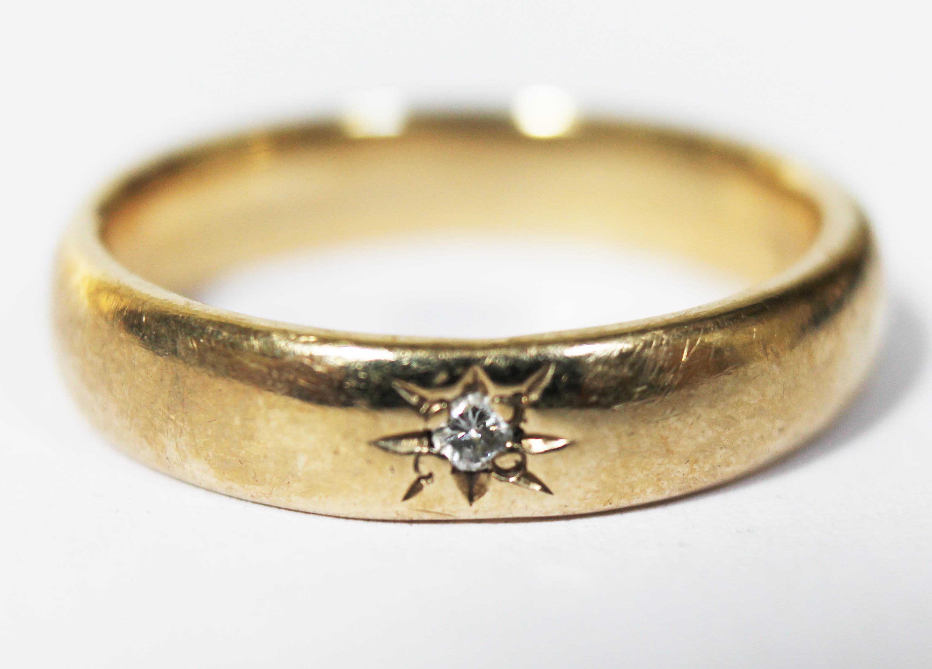 A hallmarked 9ct gold wedding band set with a diamond, gross wt. 4.4g, size N.