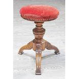 A Victorian walnut  adjustable piano stool with Aesthetic style detail.