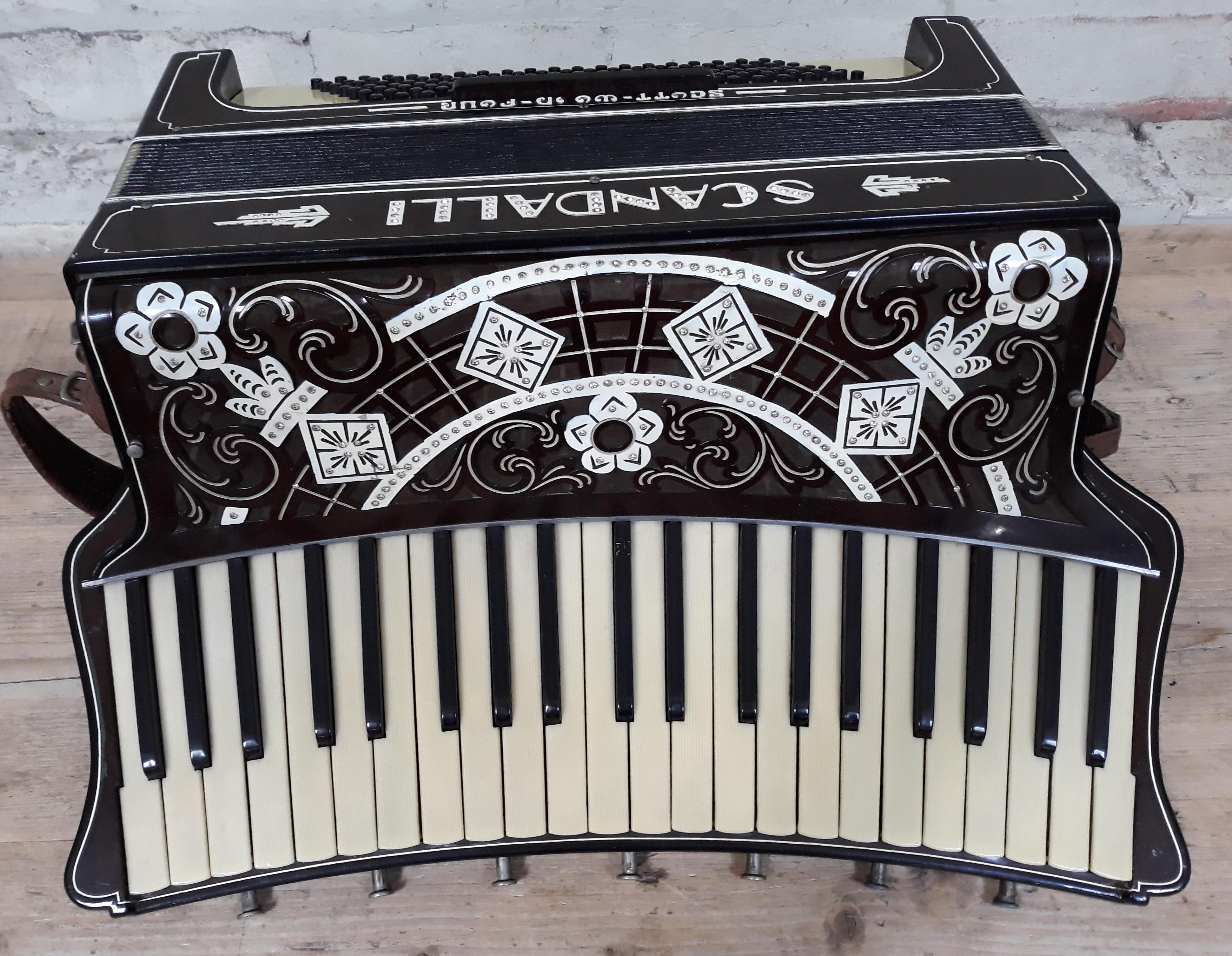 An Italian Scandalli accordion, curved keyboard with 7 couplers, inscribed '5039 Camerano Italia' to