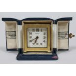 A brased cased Zenith travel alarm clock of swuare form with original blue leather box, gross height