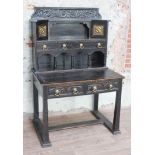 An Arts & Crafts style ebonised writing desk with superstructure, carved detail, pierced brass and