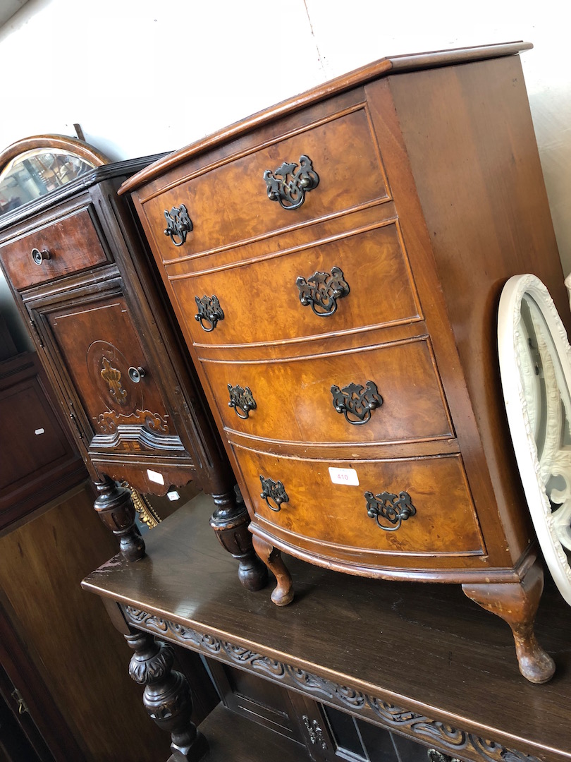 A reproduction burr walnut bow front chest of drawers with vanity lift top.