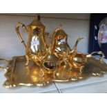 A gold plated tea set comprising tray, tea and coffee pots, milk and sugar.
